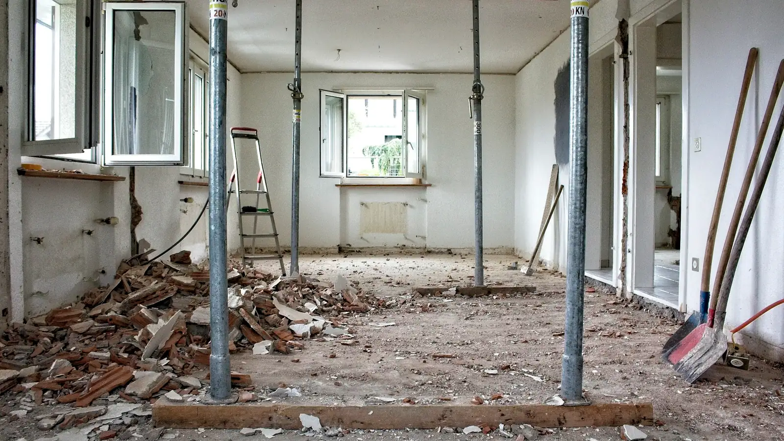 Kamer in verbouwing met stalen stempels, puin op de vloer en bouwgereedschap